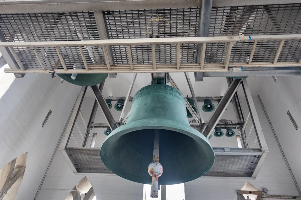 une cloche verte suspendue à une structure métallique