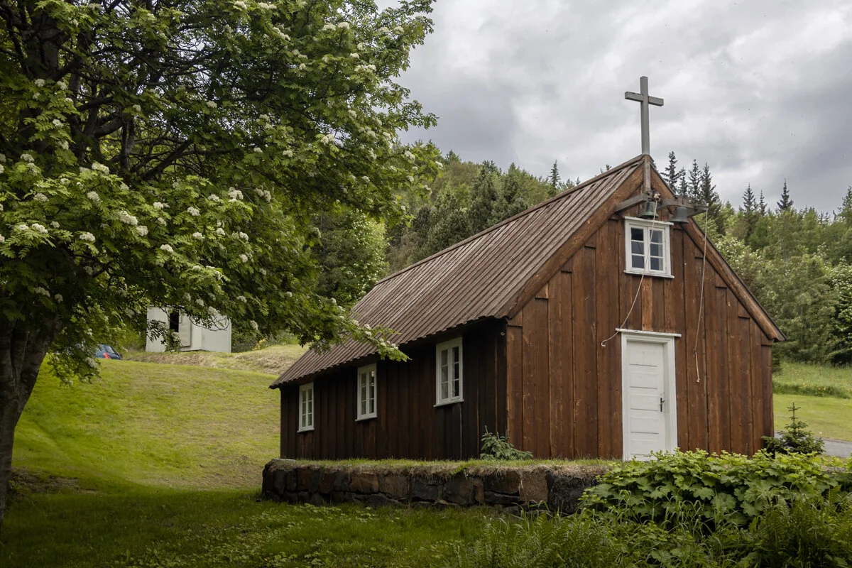 petite église en bois marron avec une croix sur le toit