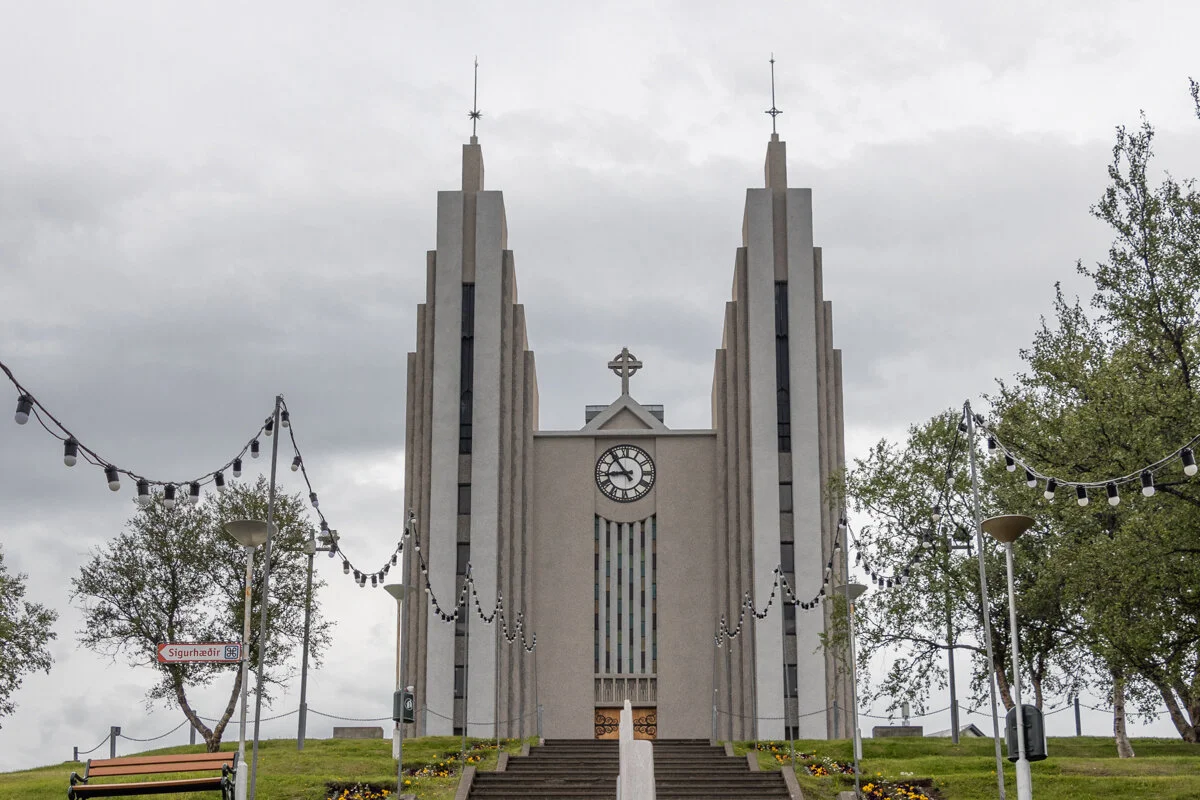 la grande église moderne d'Akureyri avec deux tours jumelles et une horloge au centre