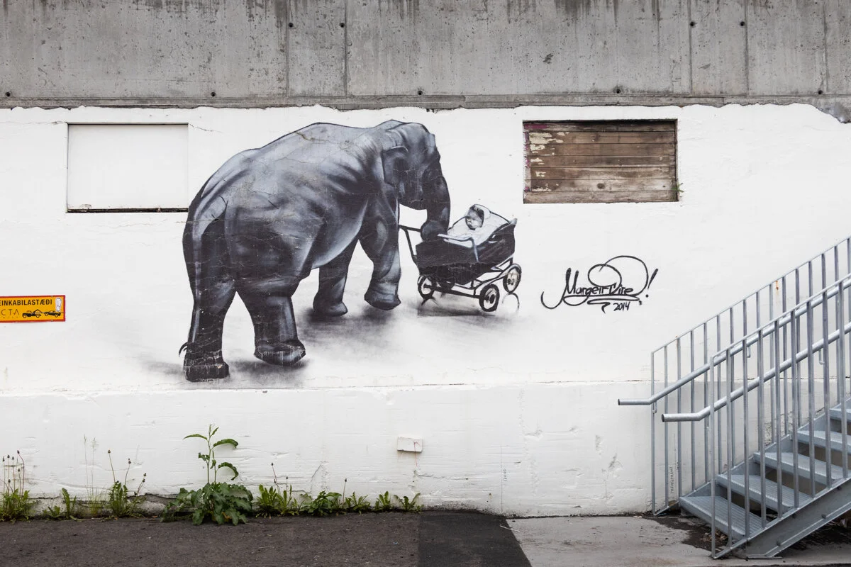 un éléphant peint sur un mur blanc avec des enfants