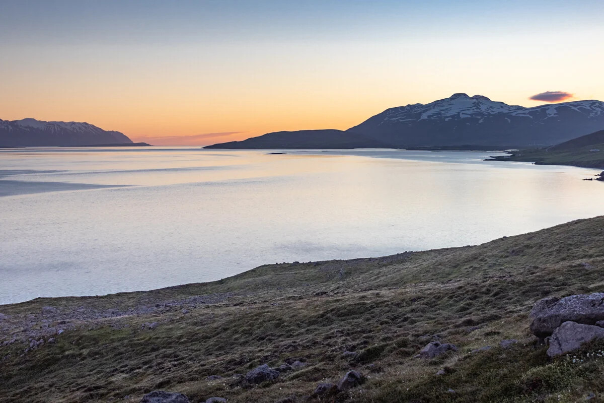 les eaux du fjord Eykafjordur au coucher de soleil avec montagnes en arrière-plan