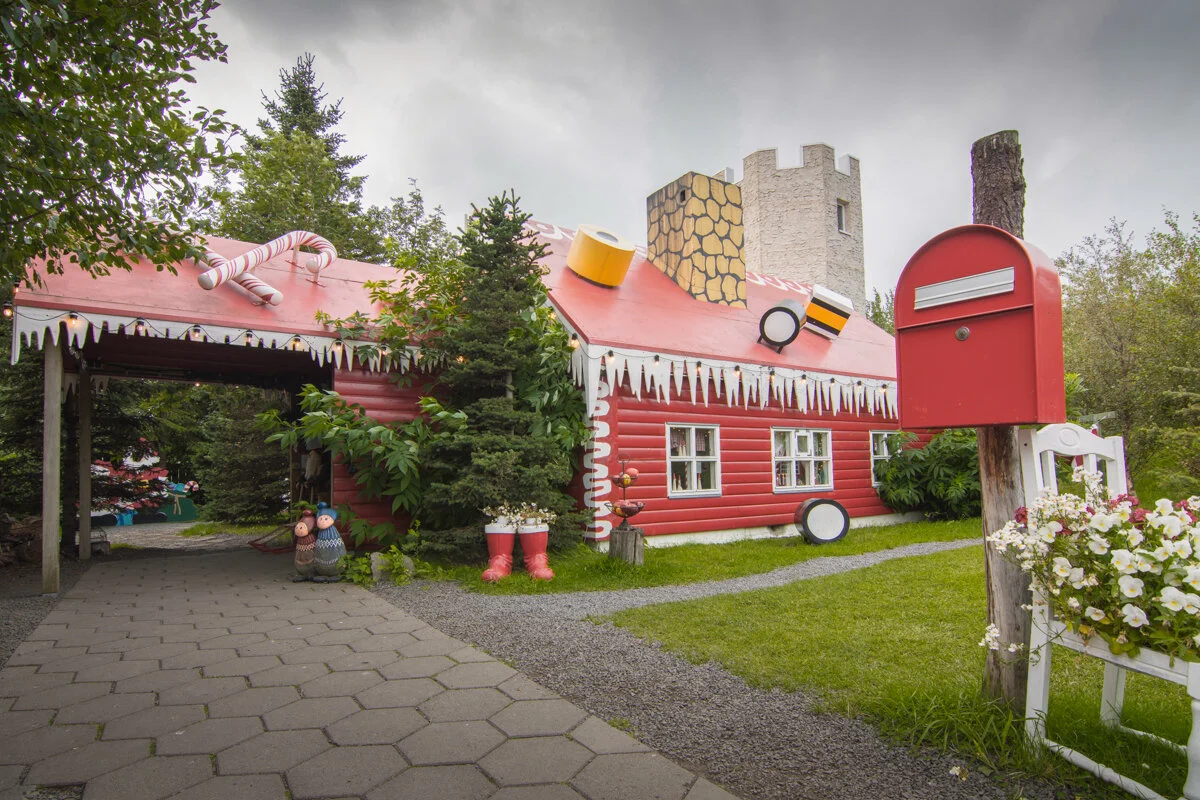 maison rouge avec boîte aux lettres et garage rose