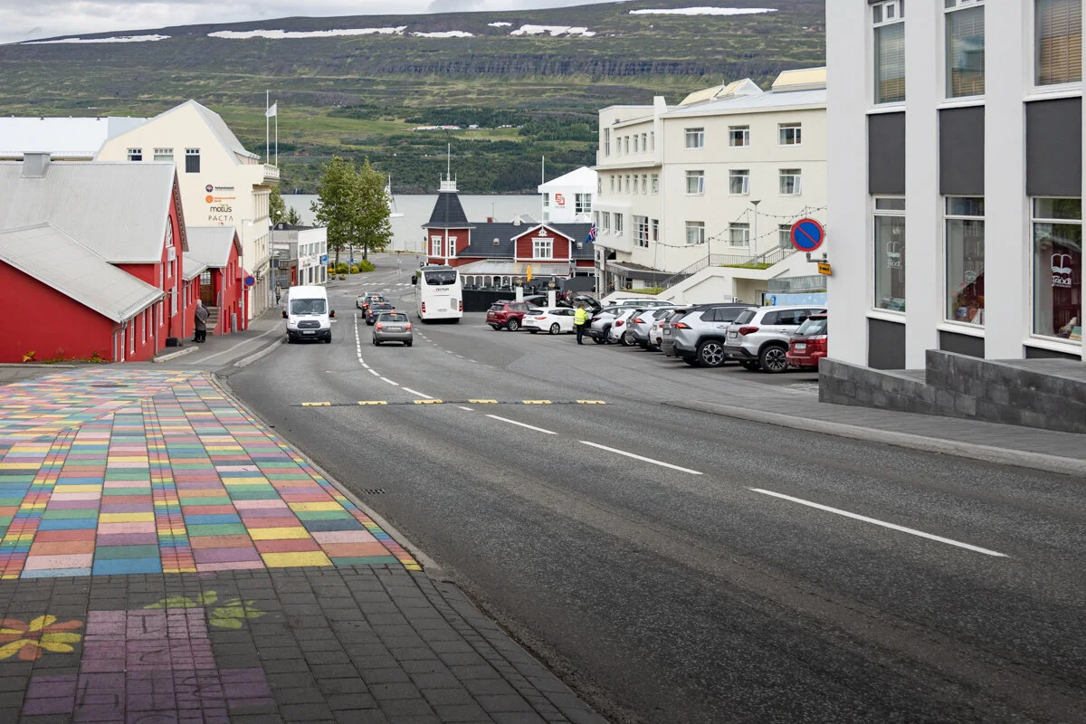 rue avec bâtiments, voitures et trottoir coloré