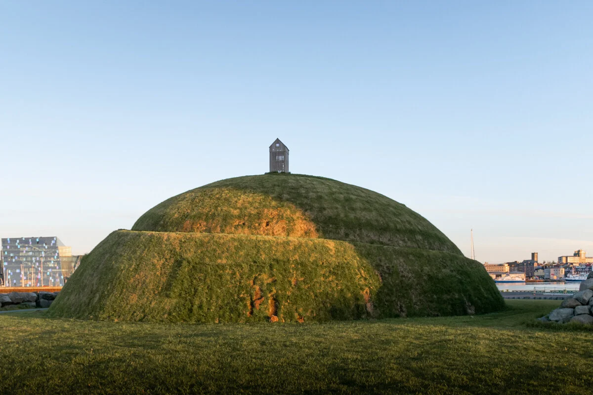 une butte avec de l'herbe (thufa) avec un cabanon au sommet