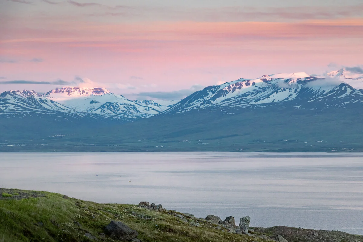 fjord, montagnes et ciel aux couleurs orangées du coucher du soleil