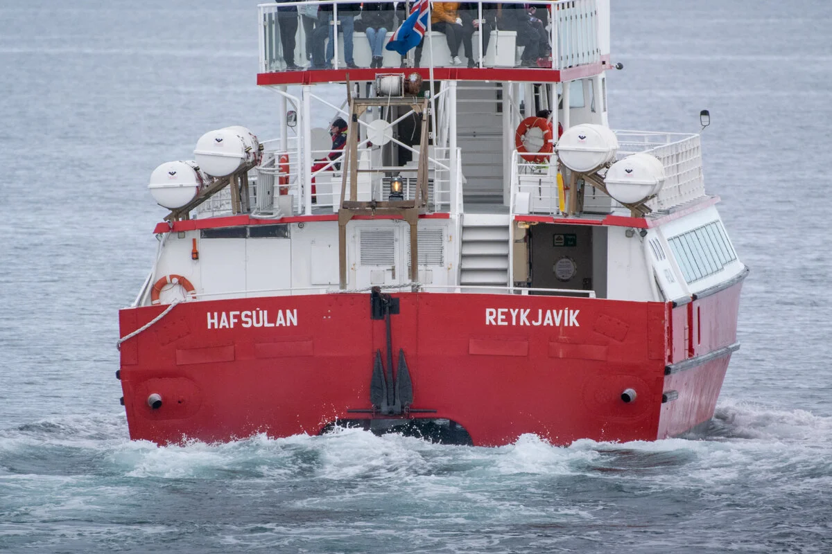 bateau rouge et blanc qui part en mer