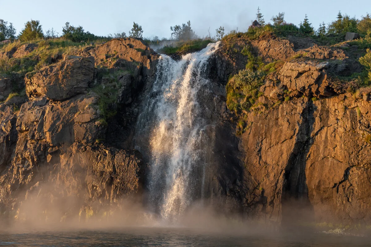 une cascade se déverse avec de la vapeur chaude