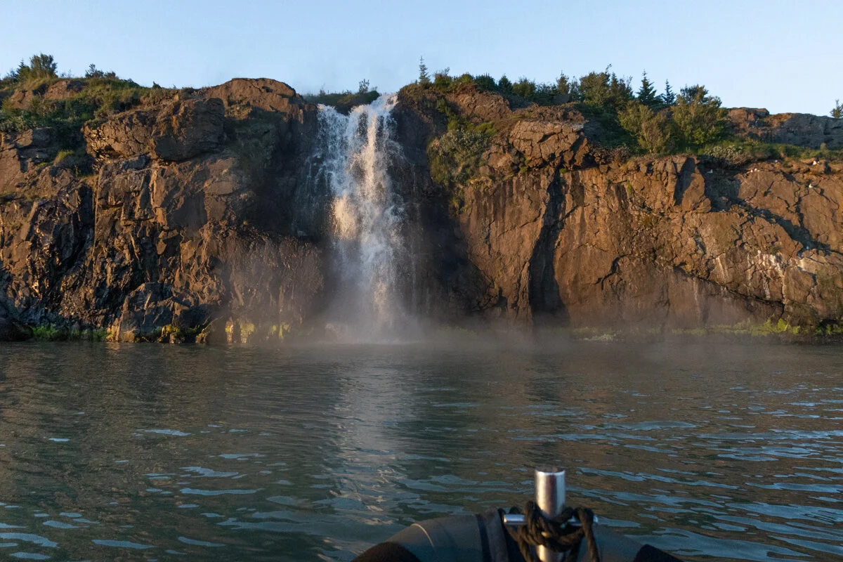 une cascade d'eau chaude se jette dans le fjord