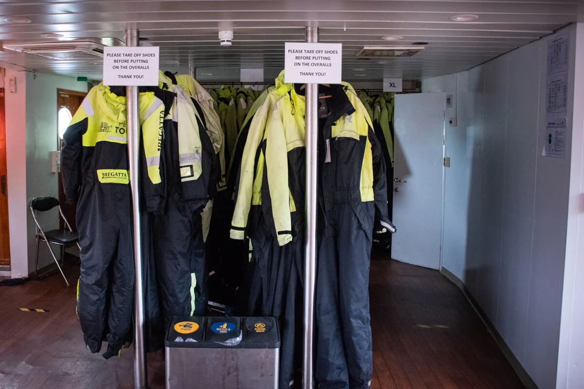 vêtements de sécurité jaunes et noirs posés sur des cintres
