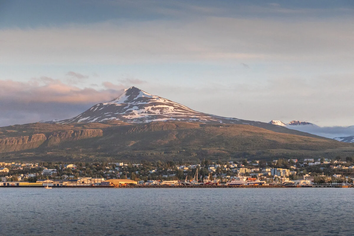 une montagne enneigée surplombant Akureyri, vue depuis la côte