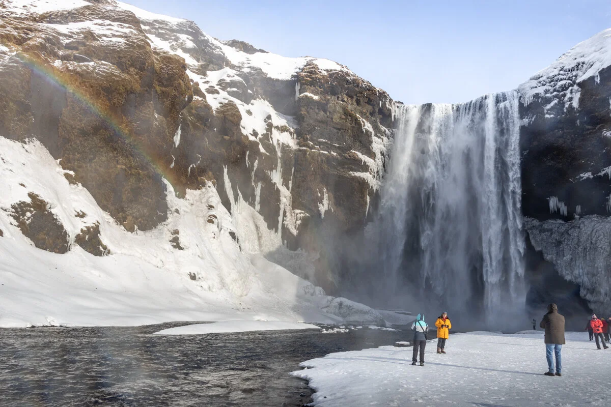 cascade d'eau dévalant une falaise rocheuse enneigée