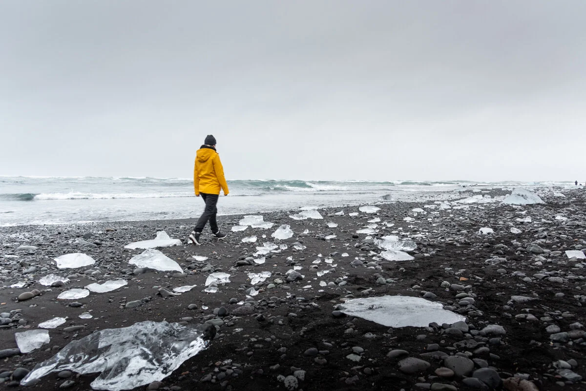 personne en ciré jaune marchant sur la Diamond Beach