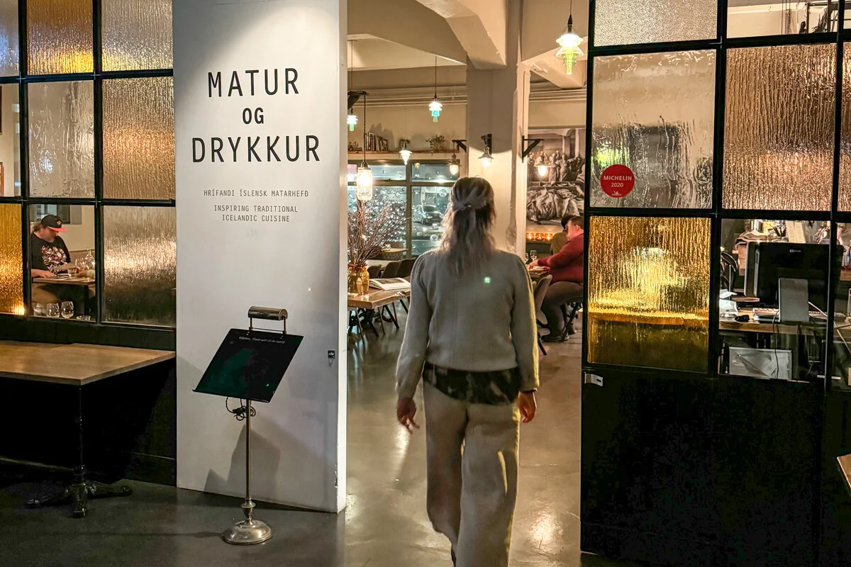 femme qui entre à l'intérieur du restaurant Matur og Drykkur