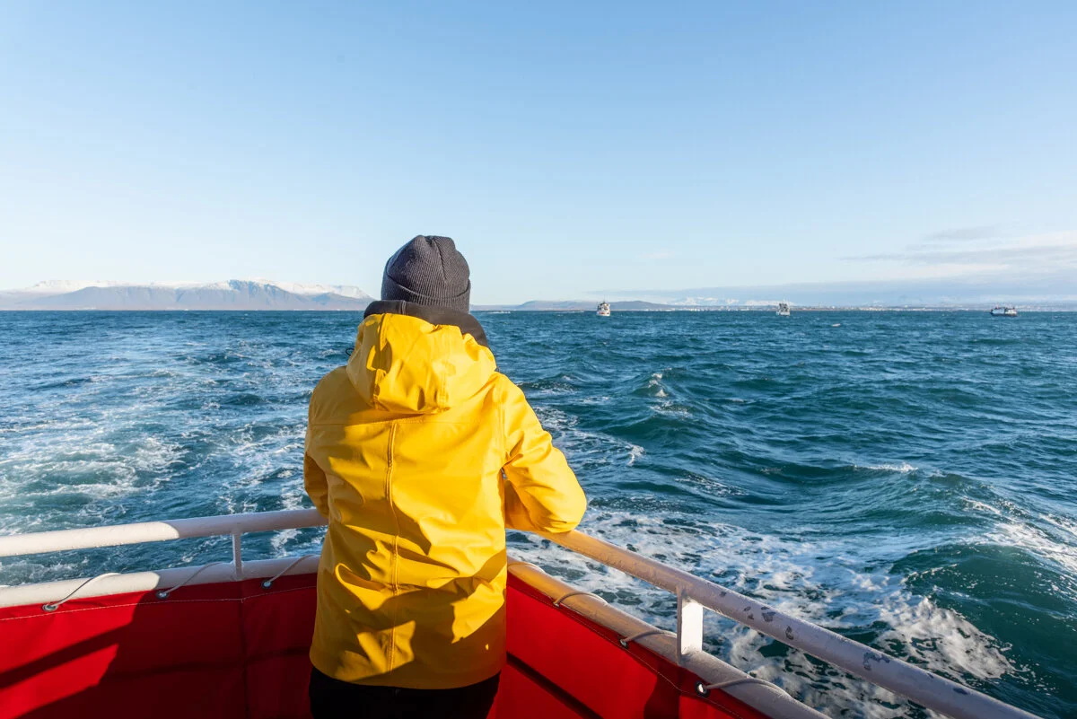 personne en gilet jaune assise dans un bateau en mer