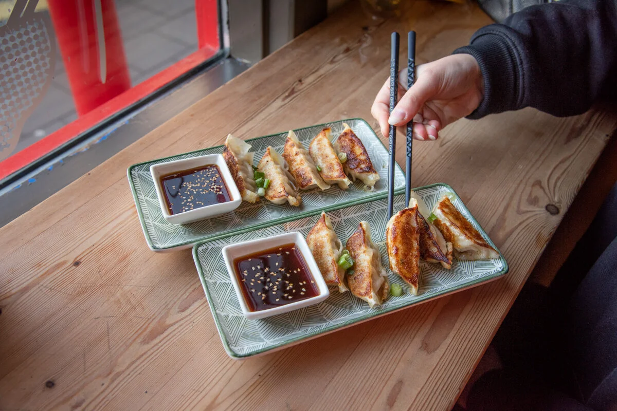 deux assiettes de nourriture japonaise avec sauces sur une table en bois