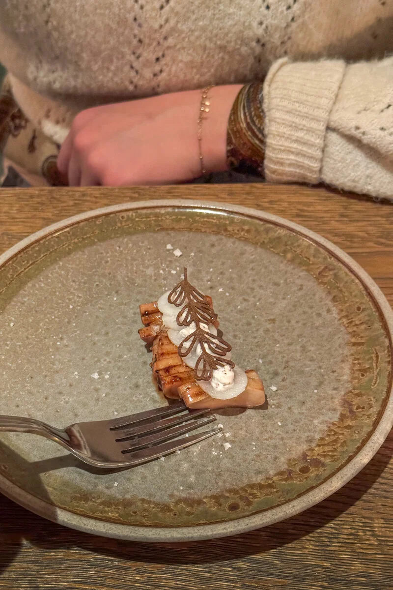 une femme qui tient une fourchette pour manger de petits amuse bouche dans une assiette