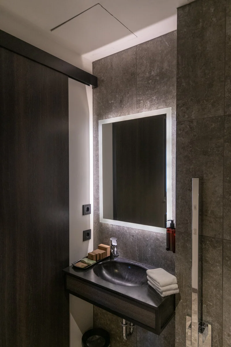 salle de bain avec miroir rétroéclairé et lavabo noir