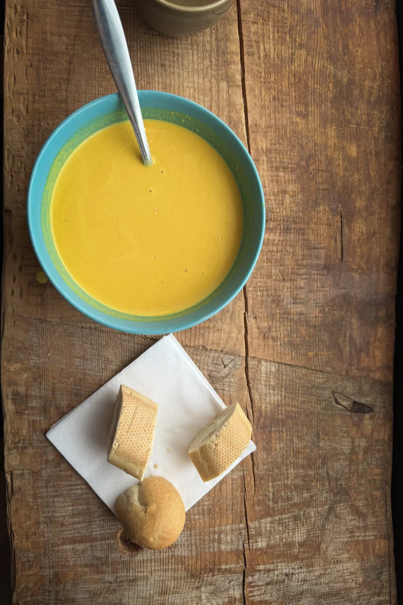 un bol de soupe avec une cuillère et des biscuits