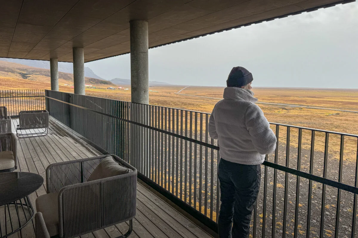 une personne observe la vue depuis une terrasse couverte