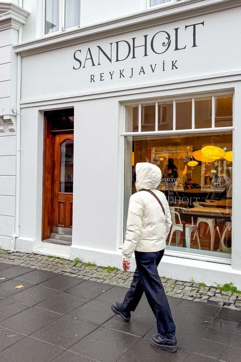 personne en veste blanche devant une boutique