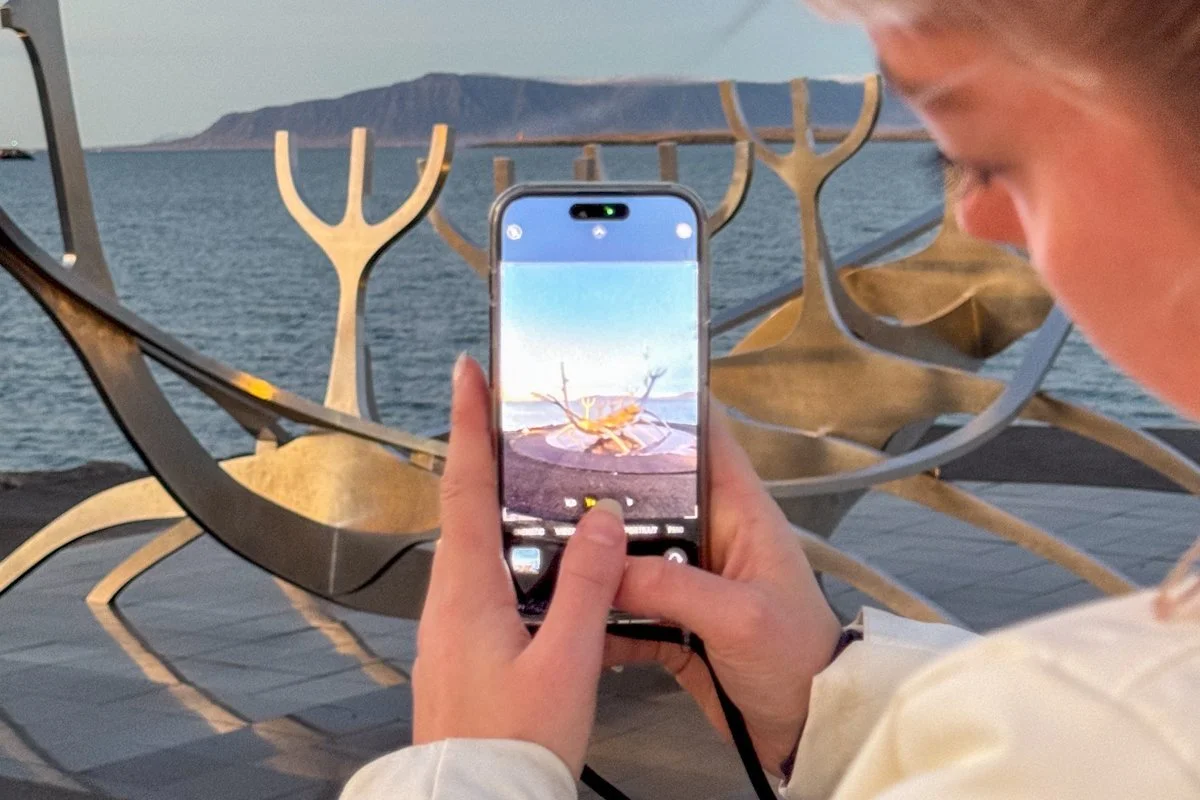 personne photographiant des structures métalliques avec un smartphone