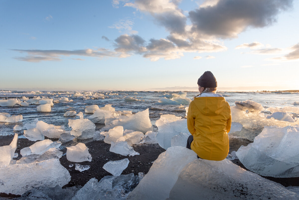 Personne assise sur un bloc de glace à Jokulsarlon